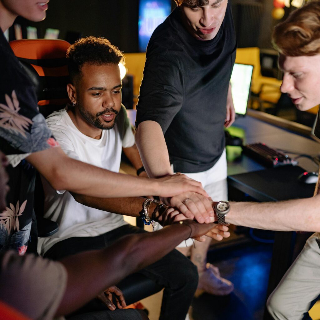 A diverse group of young adults coming together in a team building activity, symbolizing unity and teamwork.